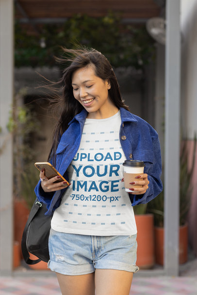Bella Canvas Tee Mockup of a Woman Checking her Phone While Drinking Coffee 