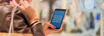 Mockup of a Woman Using a Samsung S5 in Portrait Position at a Mall