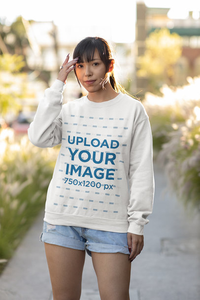Mockup of a Woman Wearing a Sweatshirt and Denim Shorts in the City