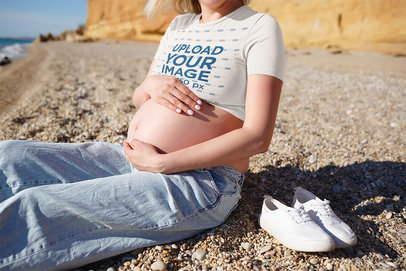 Crop Top Mockup Featuring a Pregnant Woman Sitting on a Beach