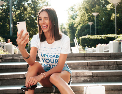 T-Shirt Mockup Featuring a Woman Making a Funny Face While Taking a Selfie