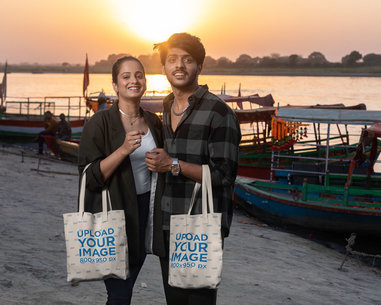 Tote Bag Mockup Featuring Two Friends Posing by a River