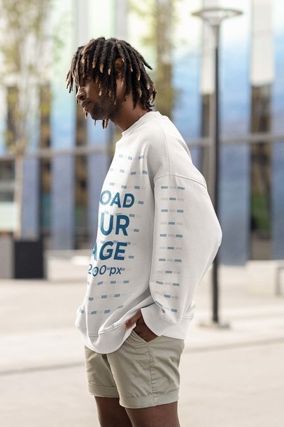 Mockup of a Man Wearing an Oversized Sweatshirt with Customizable Sleeves and Standing in the Street