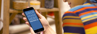 Mockup of a Woman Using an iPhone 6 in Portrait Position While Shopping