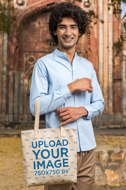 Tote Bag Mockup of a Young Man Posing in Front of an Ancient Temple
