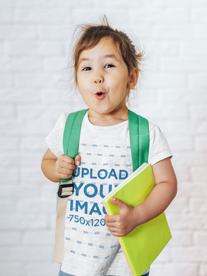 T-Shirt Mockup of a Little Girl Making a Funny Face as She's Ready for School