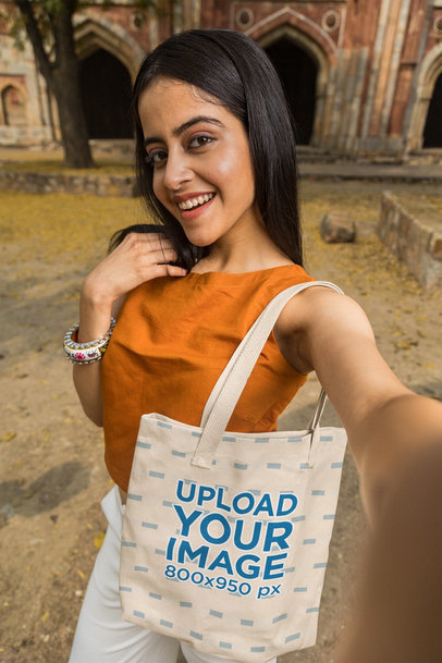 Tote Bag Mockup of a Young Woman Taking a Selfie in an Ancient Temple