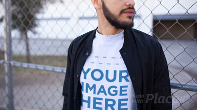 Nice Looking Guy Using T-Shirt Video Against a Fence a13472