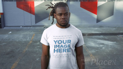 Young Man with Locs Standing in a Parking Lot Wearing a T-Shirt Video Mockup