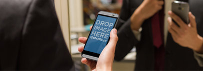 Mockup of a Man in a Suit Holding an HTC Phone in Portrait Position