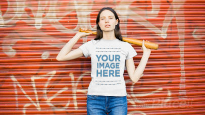 Young Woman Holding a Baseball Bat While Wearing a Round Neck T-Shirt Video Against a Closed Curtain