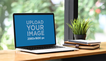 Mockup of a MacBook Placed By an Indoor Plant