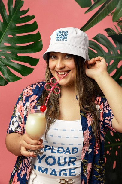 Tank Top and Bucket Hat Mockup Featuring a Smiling Woman Drinking a Mocktail