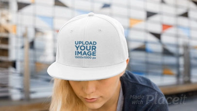 Young Woman Wearing a Snapback Hat Video Mockup While in the City