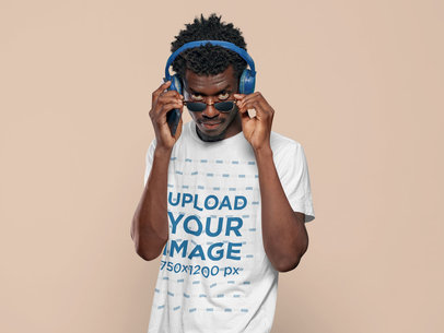 T-Shirt Mockup Featuring a Man Posing with his Sunglasses and Headphones