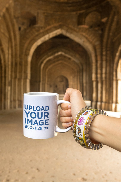 Mockup of a Woman Holding an 11 oz Coffee Mug Inside an Antique Indian Temple
