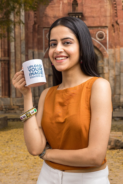 11 oz Coffee Mug Mockup Featuring a Smiling Woman by an Antique Building 