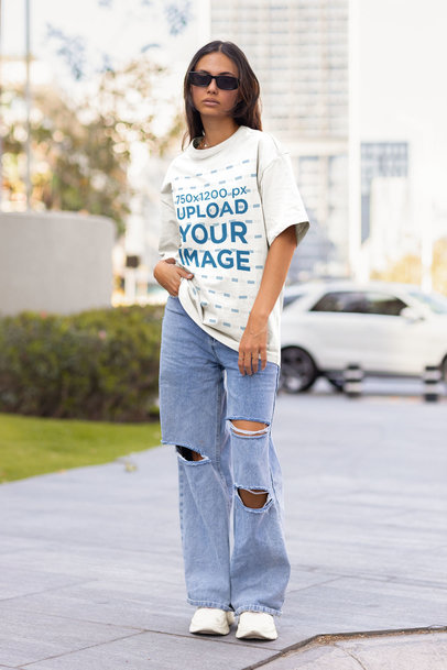 Mockup of a Stylish Woman Wearing an Oversized Tee and Ripped Jeans