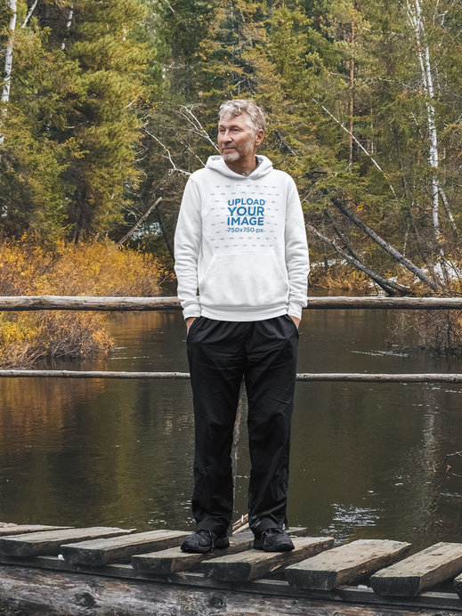 Hoodie Mockup Featuring a Bearded Senior Man on a Wooden Bridge