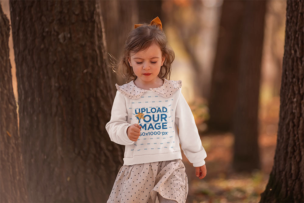 Sweatshirt Mockup Featuring a Little Girl Strolling Through the Woods