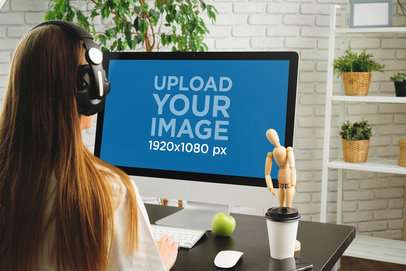 iMac Mockup Featuring a Woman Looking at the Screen and Using Headphones m18252-r-el2