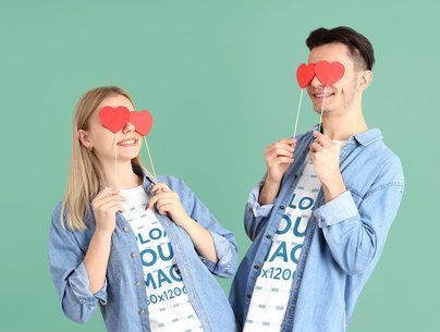 T-Shirt Mockup of a Couple Covering Their Eyes with Paper Heart-Shaped Cutouts
