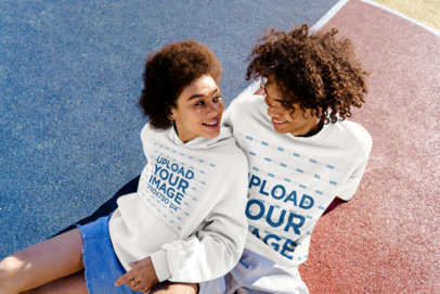 Hoodie and T-Shirt Mockup Featuring a Happy Young Woman and Her Boyfriend Sitting on the Floor