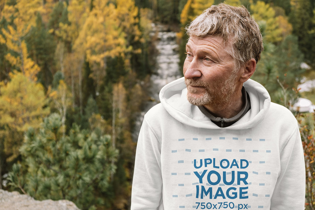 Hoodie Mockup Featuring a Senior Man and a Forest in the Background