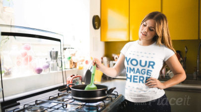 Pretty Young Woman Cooking in Her Kitchen Wearing a T-Shirt Cinemagraph