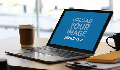 Mockup of a MackBook Placed on an Office Desk Next to a Coffee Cup m17213-r-el2