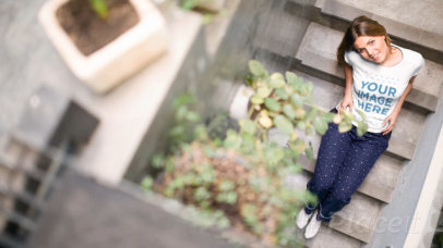 Woman Sitting Down on Concrete Stairs Wearing a T-Shirt Cinemagraph
