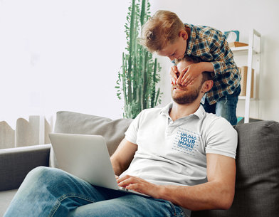 Polo Shirt Mockup Featuring a Dad Using His Laptop and Playing With His Son