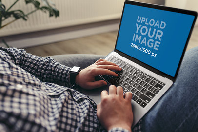 Mockup of a Man Using a MacBook at Home