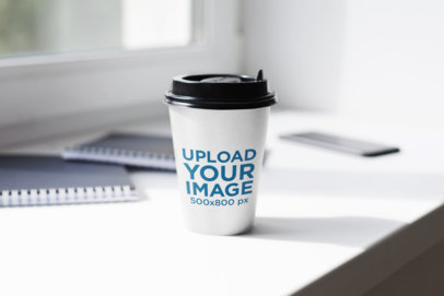 Mockup of a Paper Cup on a White Desk