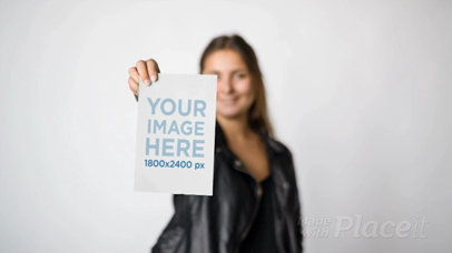 Rocker Girl Wearing a Leather Jacket Shows Your a Flyer Video While Against a White Background a13811