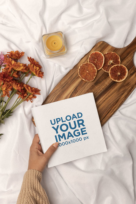 Mockup of a Square Book Being Placed on a Cute Aesthetic Setting