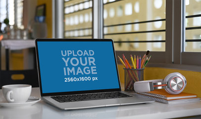 Mockup of a Macbook Placed on a Desk with a Coffee Mug and School Items M16865-r-el2