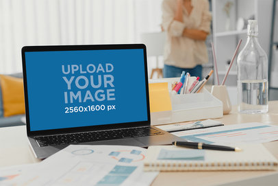 Mockup of a MacBook Pro Surrounded by Work Papers M17112-r-el2
