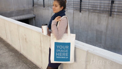 Young Woman Holding a Tote Bag While Waiting And Drinking A Coffee Video Mockup