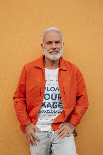 T-Shirt Mockup Featuring a Senior Man Posing Against an Orange Wall