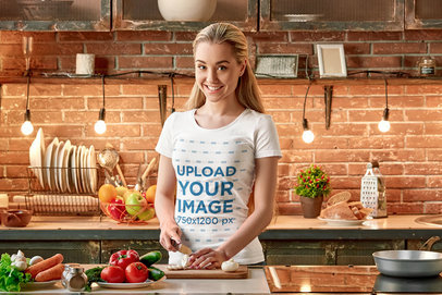 Mockup of a Woman in a T-Shirt Cutting Vegetables in a Kitchen