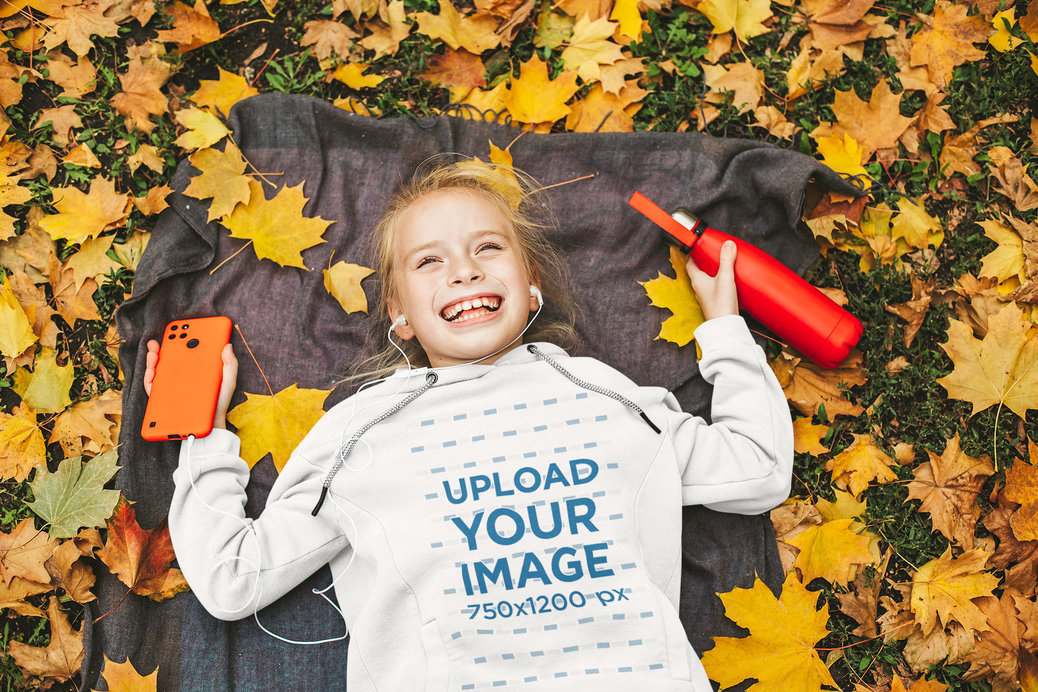 Hoodie Mockup Featuring a Girl Laughing and Some Dry Leaves