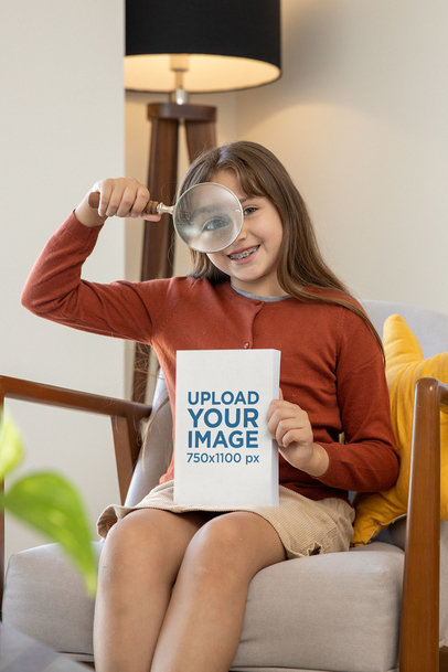 Book Mockup of a Girl Playing with a Magnifying Glass in Her Living Room m26924