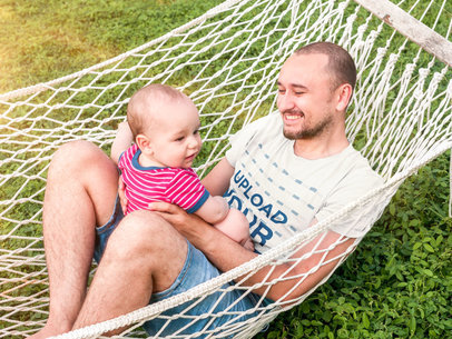 T-Shirt Mockup of a Man Playing With His Son on a Hammock