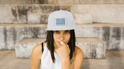 Woman Wearing a Snapback Hat Video While Sitting on Stairways Making Faces