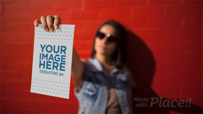Woman Playing to be a Mannequin While Holding a Flyer in Stop Motion Near a Red Wall