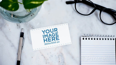 Business Card in Stop Motion Lying on a Granite Desk Near Accessories Moving a13871