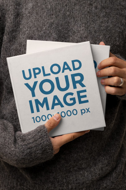 Mockup of a Woman Showing Two Square Books m26950