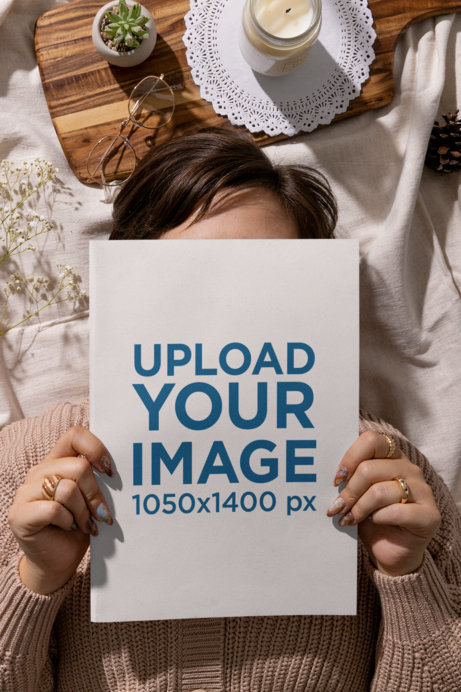 Mockup of a Woman Holding a Book to Her Face Surrounded by a Cottagecore Setting 
