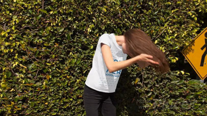Trendy Girl Flipping her Hair in the Street Wearing a Round Neck T-Shirt Stop Motion a13161